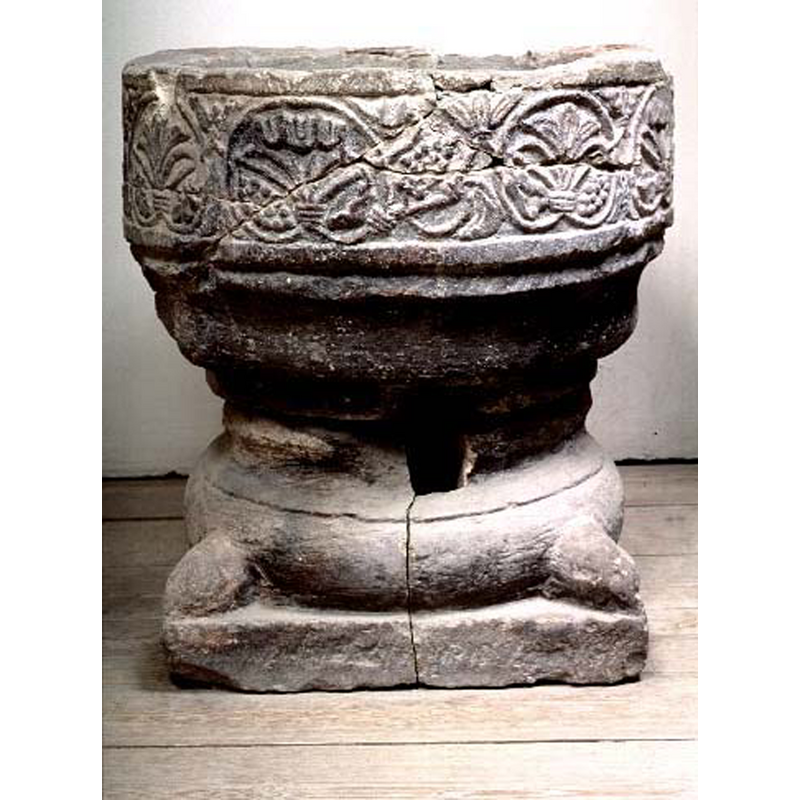 Source caption: "funten sprängdes sönder vid en brand i kyrkan år 1909, delarna är nu sammanfogade " -- the badly damaged font originally from Östra Torps gamla kyrka as displayed in the Lunds universitets historiska museum (inv.nr. 24363)
