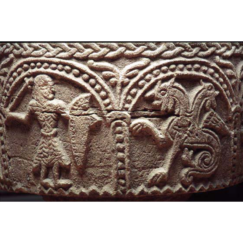 the end of the mace is cross-shaped, and is similar to the object being held by one of the fabulous beasts in another arch