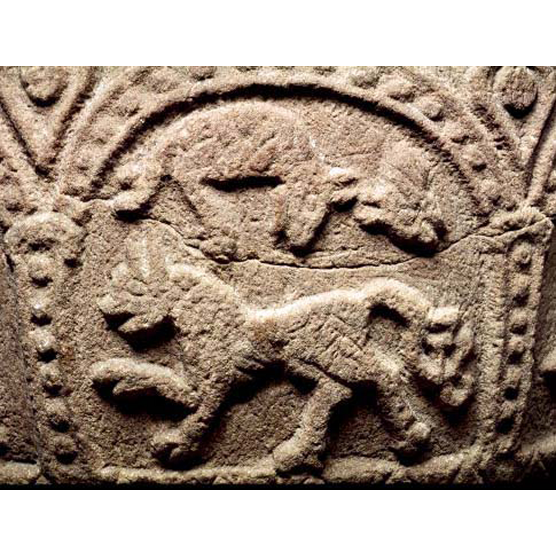 in the arch to the left of the Agnus Dei: a quadruped with a floriated tail, passant to the left; above it two animal heads, the one of the left with part of its body visible -- captioned "fyrfotingar, tre stycken i grupp" in the SHM