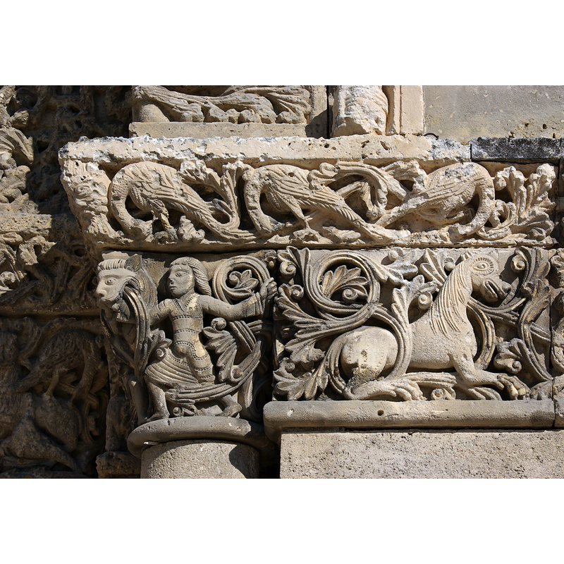 Source caption: "Motifs renvoyant aux règnes humain, végétal et animal : chapiteau et frise du portail de l'église Saint-Pierre (XIIe et XVe siècle) de Châteauneuf, Charente, France"