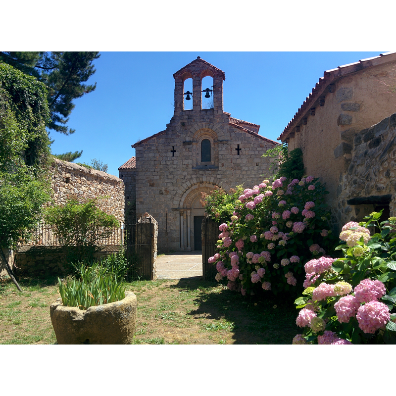 Source caption: "Església de Sant Pere Cercada (Santa Coloma de Farners)" -- the tub vessel seen here, in front of the west portal of the church, may be the discarded medieval font of the monastery church
