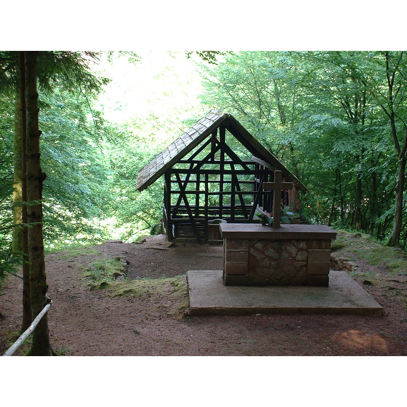 the ruins of the former chapel; behing the altar, in the enclosed space, is the medieval tub font