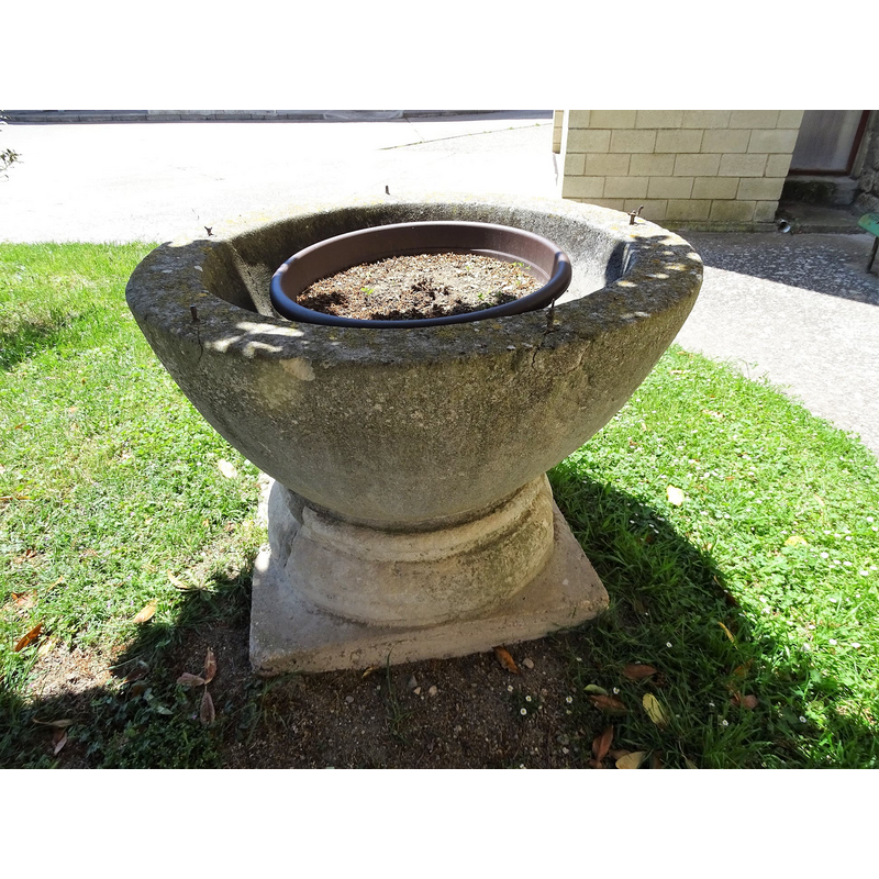 the old font outside the modern church