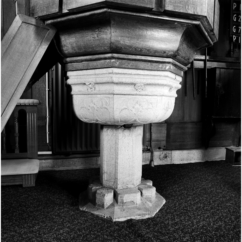 the stone font supporting the wooden pulpit