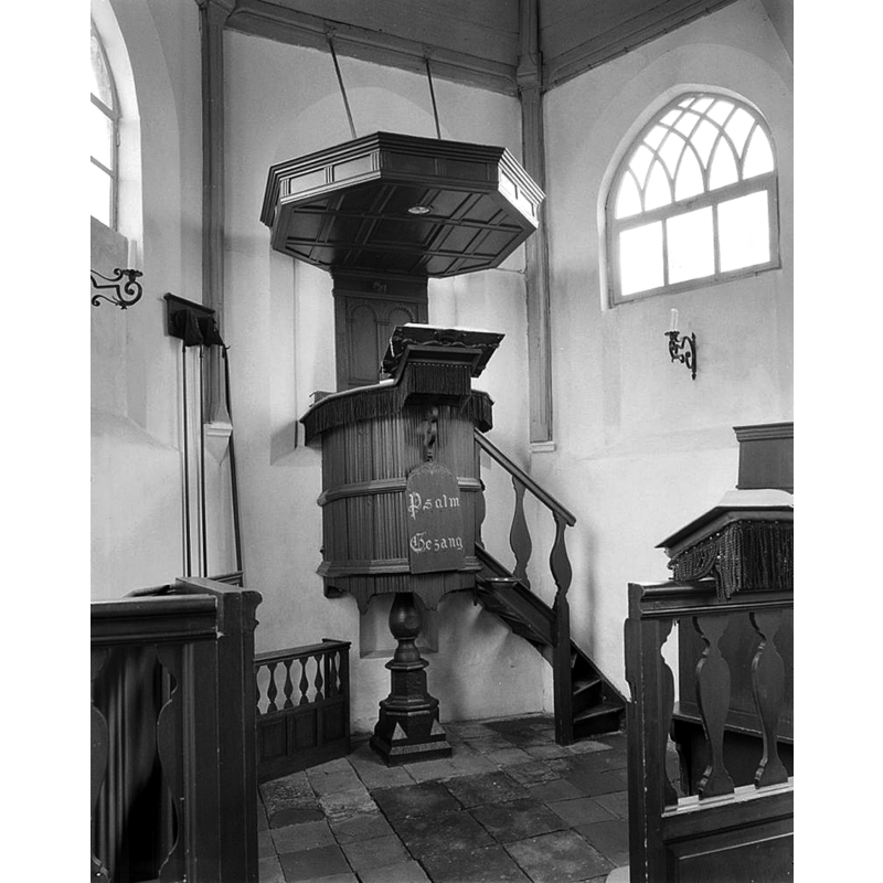 Source caption: "N.H.Kerk: interieur, preekstoel' -- showing the base of the baptismal font still attached as support of the pulpit