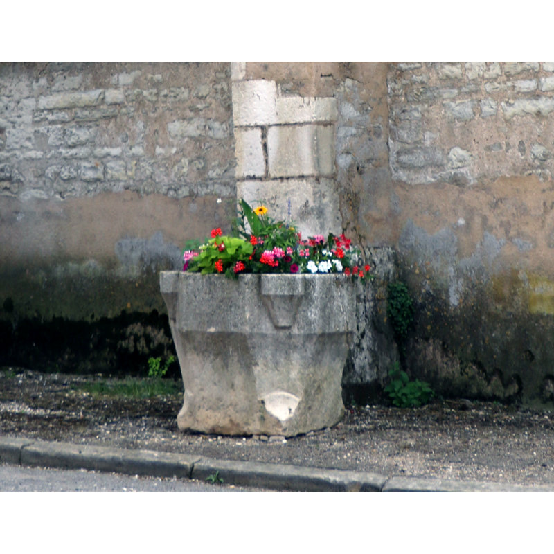 a former baptismal font(?) used as planter outside the church