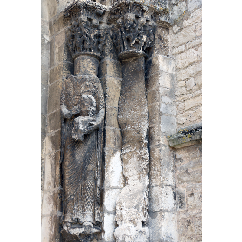 Madonna and Child on the left; lost statue on the right -- the Revolution left a sad trail on the portal of this church