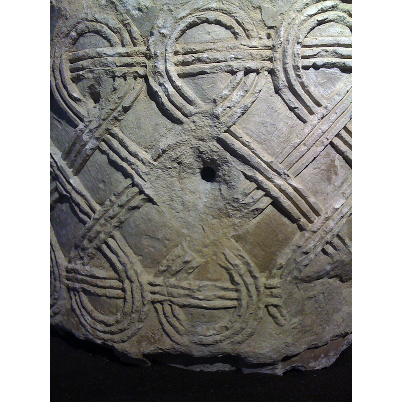 forming "8" motifs all around -- the hole in the middle was probably made for the use of this object as a trough or planter after it was removed from the church