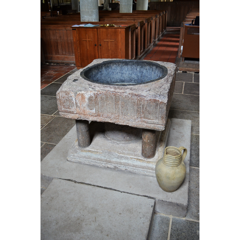 Source caption: "The font is 12th century, made of Bethersden marble, now standing on a modern support. It was once discarded and used as in a farmyard."