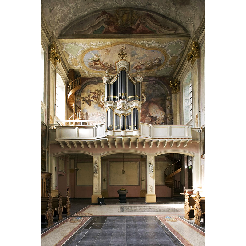 Source caption: "Sint Gerlachuskerk: Interieur, overzicht van orgel met muurschilderingen en plafondschilderingen, na de restauratie." -- the baptismal font at the west end of the nave, beneath the organ loft