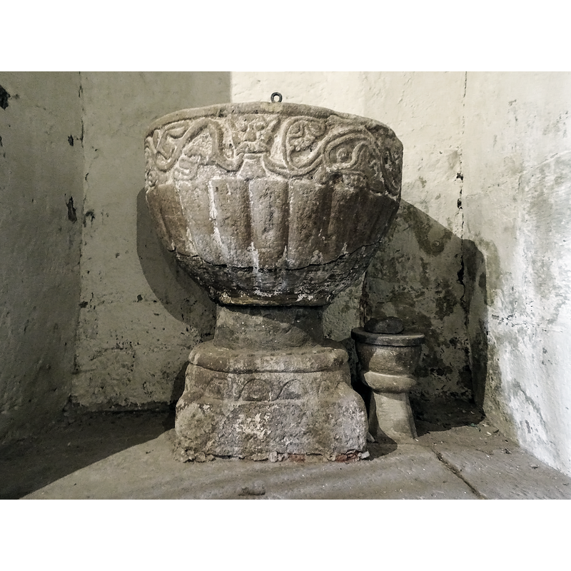 the baptismal font in the narrow space at the west end of the nave