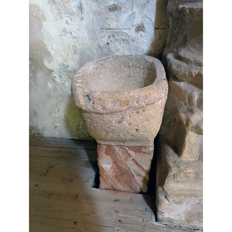 this object is set up now as a stoup in the proximity of the baptismal font, but it appears to be a composite of two unrelated parts, the upper one perhaps a former grain measure or similar, rather than a liturgical furnishing