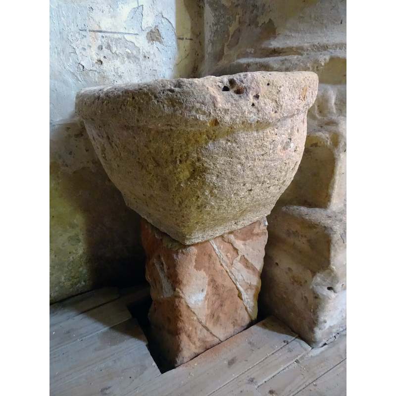 this object is set up now as a stoup in the proximity of the baptismal font, but it appears to be a composite of two unrelated parts, the upper one perhaps a former grain measure or similar, rather than a liturgical furnishing