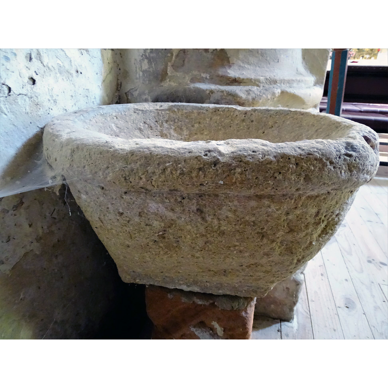 this object is set up now as a stoup in the proximity of the baptismal font, but it appears to be a composite of two unrelated parts, the upper one perhaps a former grain measure or similar, rather than a liturgical furnishing