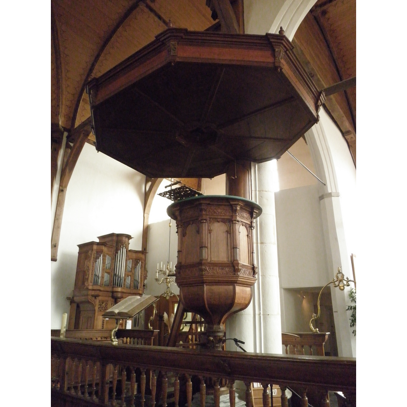 Source caption: "Kansel van de Noorderkerk van Hoorn. Er achter een klein orgel." -- the stone base of the 1635 wooden pulpit is discernible between the railings in the foreground