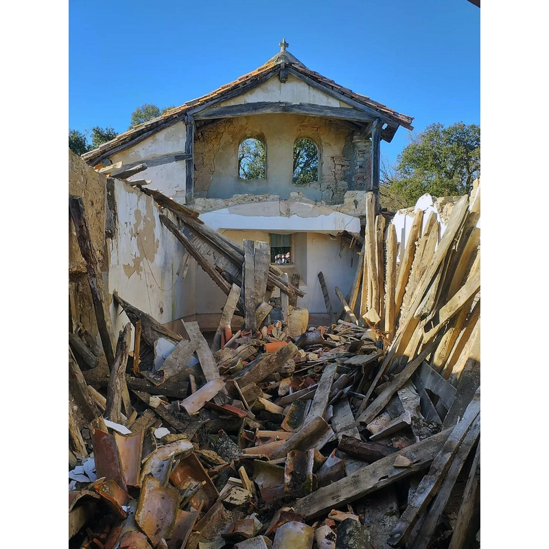 the church in February 2022 -- the belfry still stands and retains its roof, but the main roof has collapsed since 2017; the font is discernible among the debris at the far end
