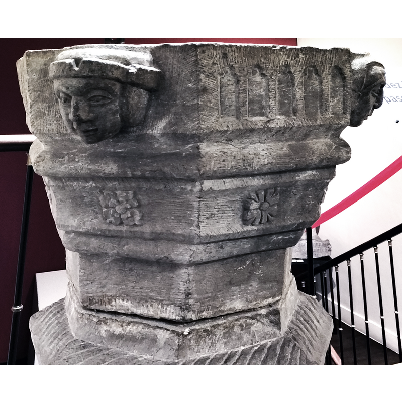 carved on the panels between the heads