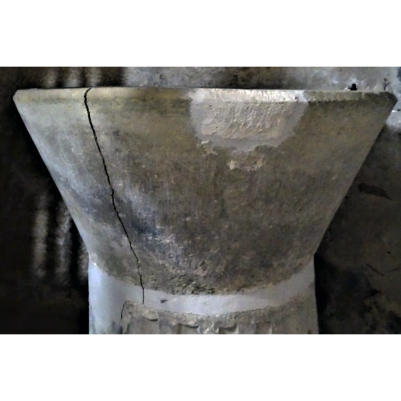 large vertical crack on the left; repair of anchoring damage on the right