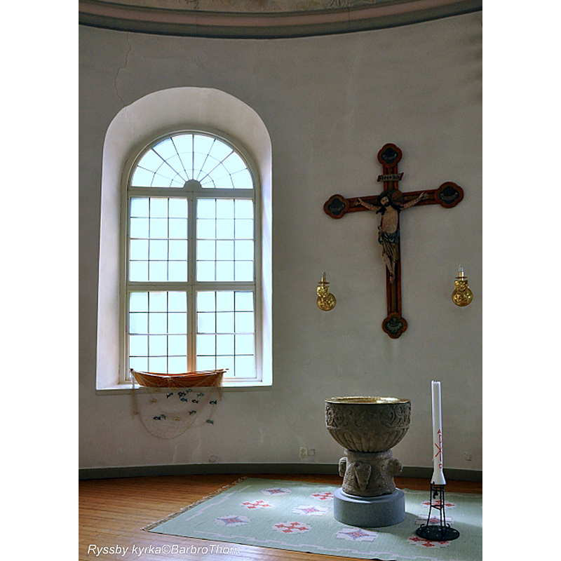 Source caption: "Dopfunt från 1200-talets början, tillhör dem s k Vitabygruppen" -- the medieval font in the southeast corner of the new church