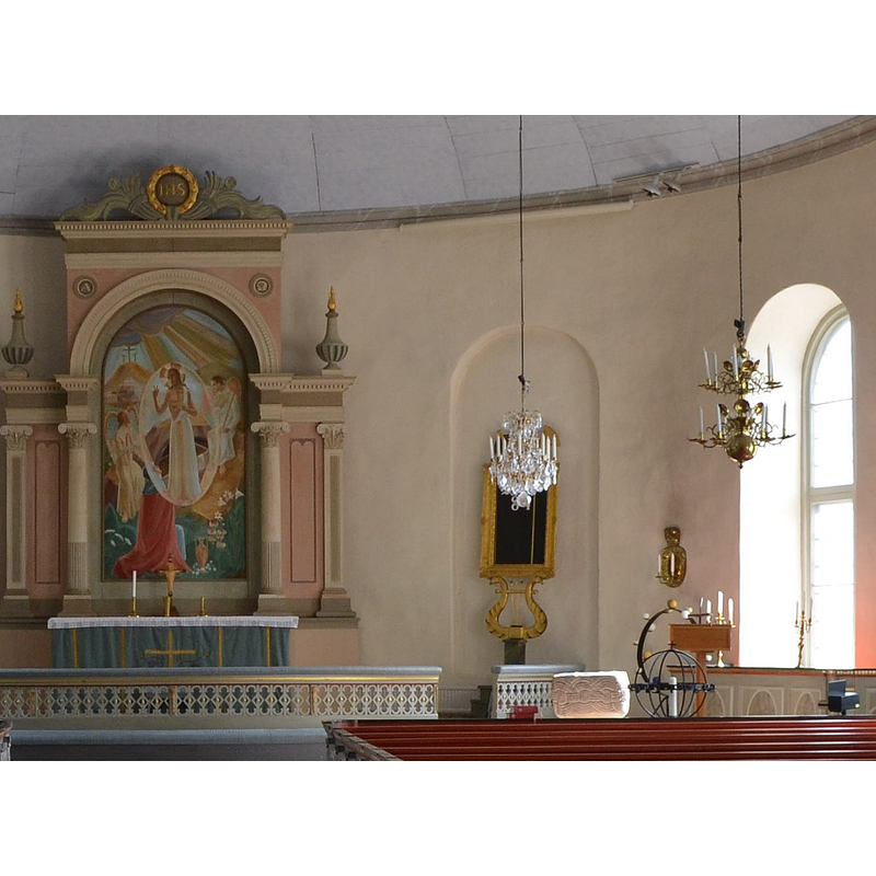 the top of the medieval font is visible behind the benches