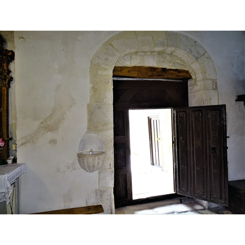 with a wall-mounted stoup to the left of the doorway