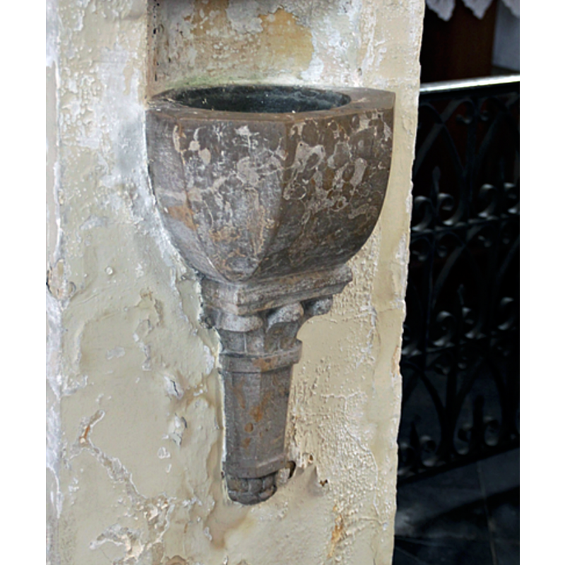 a wall-mounted stoup inside the modern church