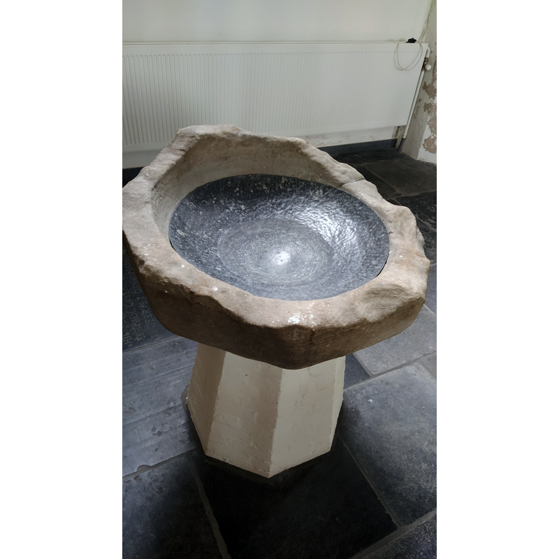 the fragment of the original font now mounted on a modern pedestal base
