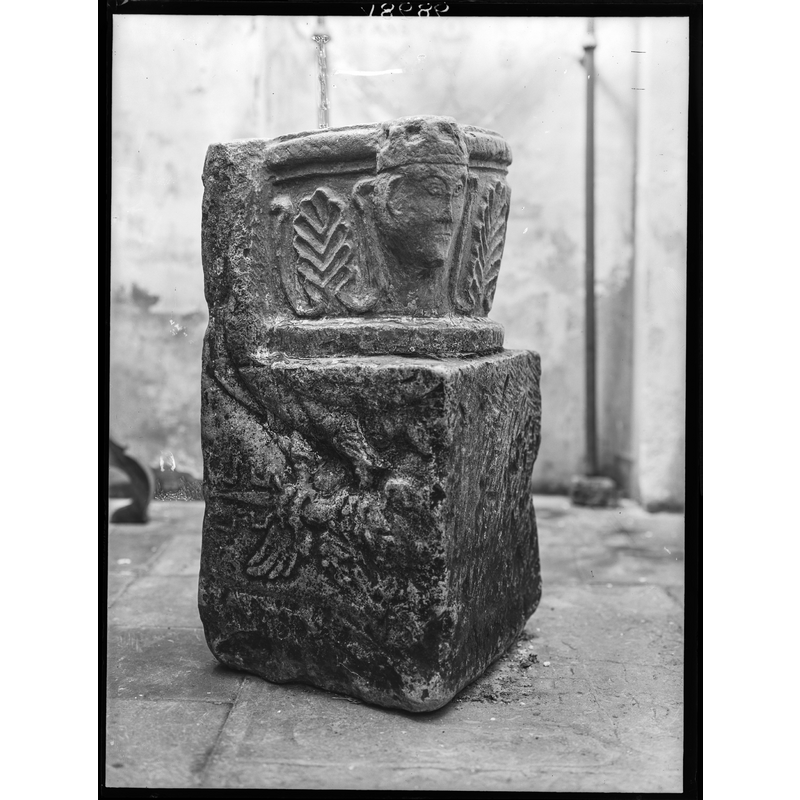 Source caption: "Description: Blok met romeinse ornamenten (IIe-IIIe), bovendeel in de XIIIe eeuw uitgehold en versierd met romaans ornament; eertijds als wijwatervat gebruikt."