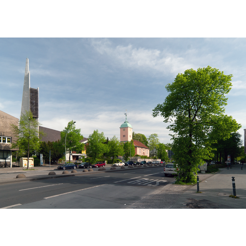 Source caption: "View north along Hauptstrasse street in Berlin-Schöneberg. You can see the older Dorfkirche (Village church) and the newer Paul Gerhardt Church"