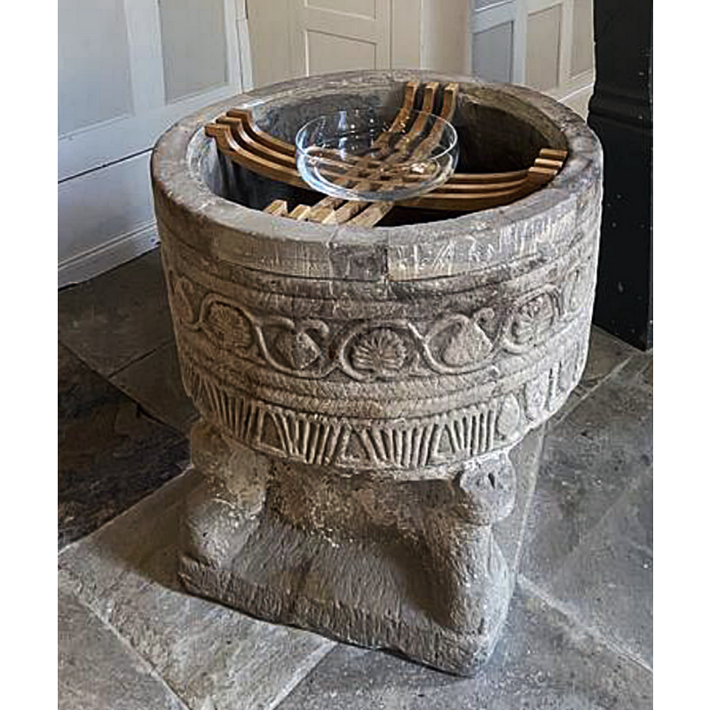 the medieval font is seen here with a simple glass baptismal dish