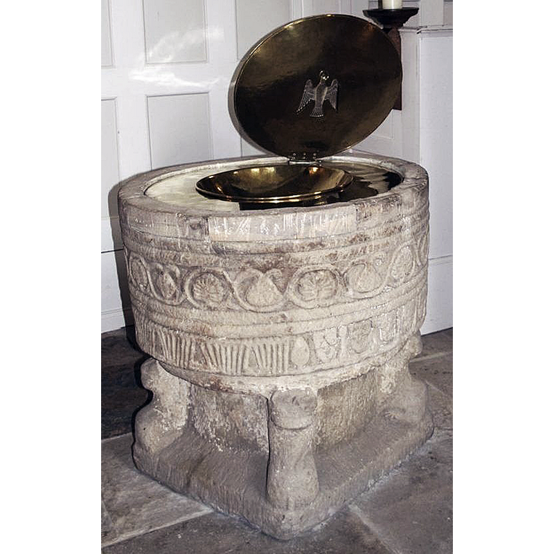 the medieval font is seen here with a more ceremonial metal baptismal dish and cover