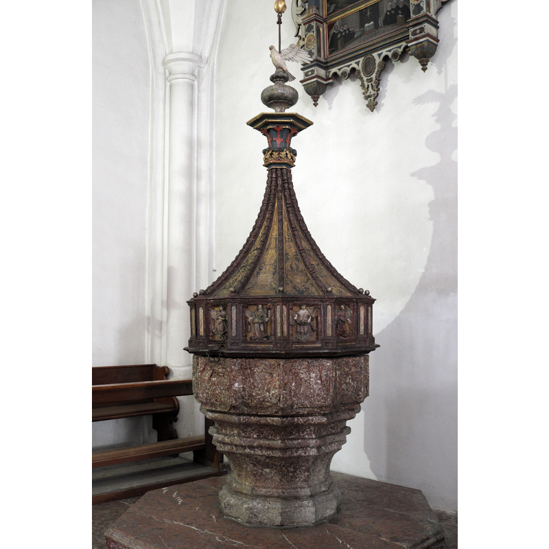 Source caption: "Katholische Pfarrkirche, ehemalige Stiftskirche des Augustiner-Chorherrenstiftes St. Zeno in Bad Reichenhall im Landkreis Berchtesgadener Land (Bayern/Deutschland), Taufstein von 1522, am Holzdeckel Reliefs von Engeln mit Leidenswerkzeugen"