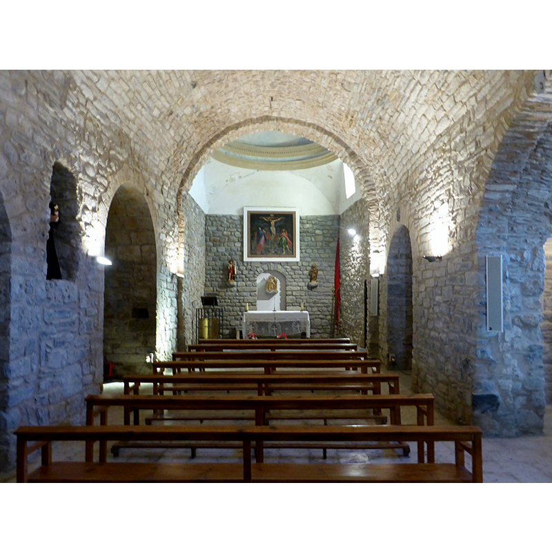 Source caption: "La cabecera, orientada al este, es rectangular, probablemente del siglo XVIII cuando debió sustituir el ábside semicircular primitivo, del cual se conservan tres arcuaciones en el interior del campanario. Se conserva el arco de medio punto de articulación con la nave, que es de tosca, y parte de las pilastras de las que arrancaba."