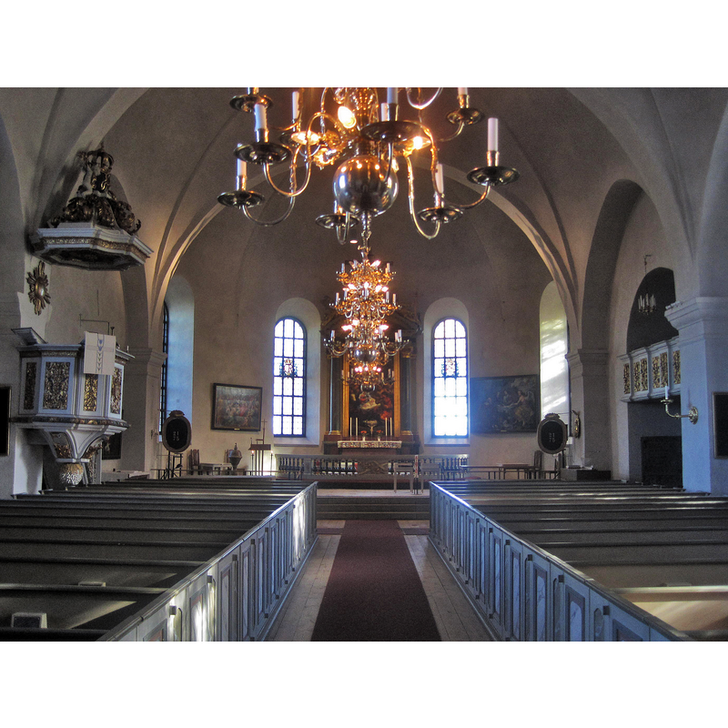 Source caption: " Interiör från sv:Mariefreds kyrka. Altaruppsatsen i Mariefreds kyrka skulpterades 1689-1690 av hovbildhuggaren Caspar Schröder (1652-1710)." -- the wooden font is visible to the left of the altar, beneath the painting