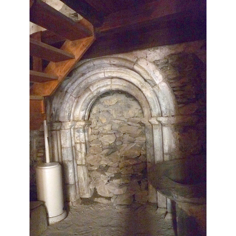 Source caption: "Santuari de Montgarri (Naut Aran): antiga portada romànica" -- the basin fragment is seen here on the right of the old Romanesque portal inside the church in July 2015
