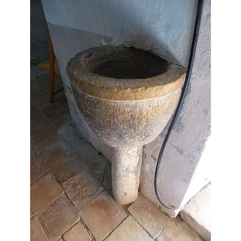 Source caption: "A la derecha de la entrada hay una pila de agua bendita, semiempotrada, con pie."