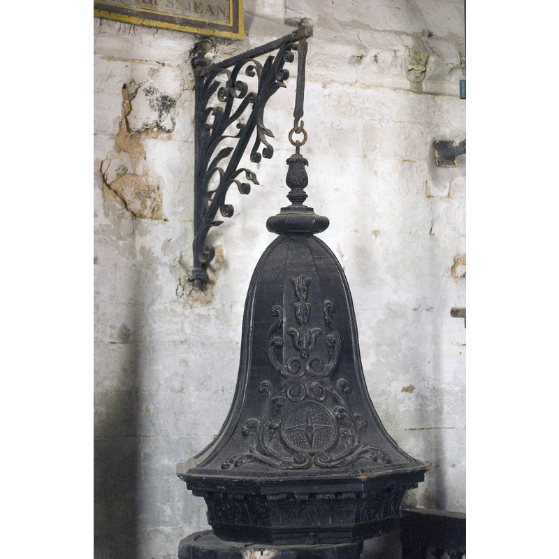 the striking campaniform font cover; the metal wall-mounted crane is visible here