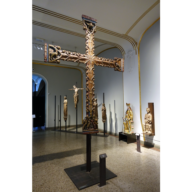 Source caption: "«Borrekorset» («Det hellige korset i Borre») fra slutten av 1200-tallet. Opprinnelig fra Borre kirke, en middelalderkirke fra 1100-tallet utenfor Horten i Vestfold. Kors av furu, med utskjæringer. krusifiks der trolig kristusfiguren mangler, selv om det ikke er naglehull etter en festet figur. Korset er dekket av vinranker, Korsarmene er dekorert med treflikede medaljonger. De tre øverste viser symboler for evangelistene (ørn for Johannes, bevinget okse for Johannes og bevinget løve for Markus), det nederste viser Kristus i limbus. Foto tatt 26. februar 2020 i Middelaldersalen i Kulturhistorisk museum i Oslo."