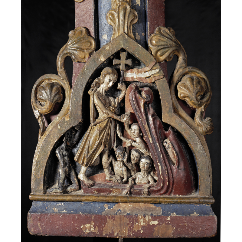 Source caption: "Borre, Cross. Detalj av kors 'Kristus i dødsriket'. Kors, kristusfiguren mangler. Korset er dekket av vinranker. Korsarmene er dekorert med treflikede medaljonger. De tre øverste inneholder utskjærte symbolder for evangelistene, det nederste viser Kristus i limbus. Korset har ingen naglehull etter en festet kristusfigur."