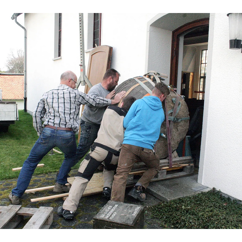 the medieval basin being brought into the new church after restoration