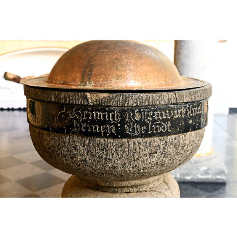 Source caption: "St. Clemens (Heimbach), barocker Taufstein, laut Inschrift von vier Ehepaaren im 17. Jh. gestiftet"