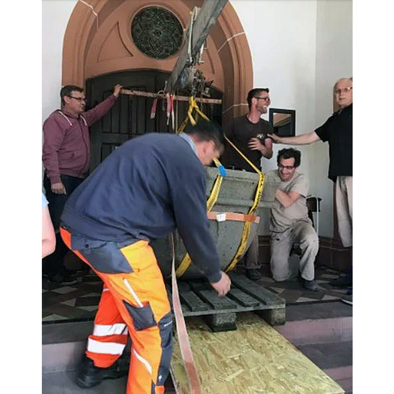 the font on a pallet being moved inside the church