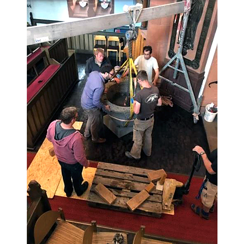 the medieval basin being raised onto the modern base