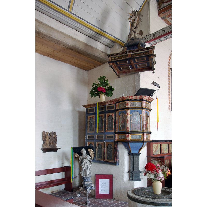 the pulpit in the centre of the image; the top of th baptismal font in the bottom-right corner