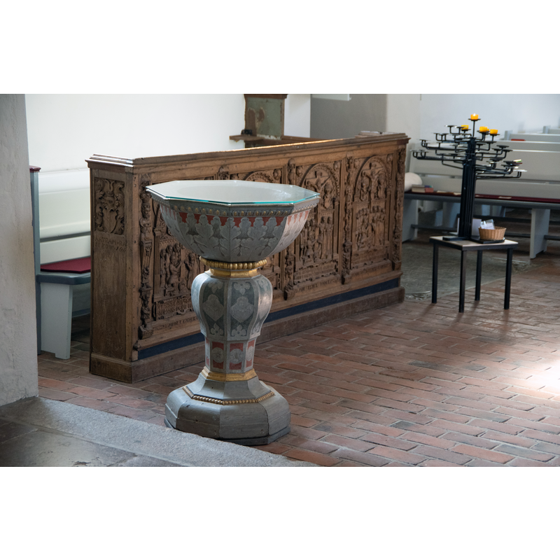 Source caption: " Waabs in Schleswig-Holstein. Die Kirche in Kleinwaabs, einem Ortsteil von Waabs steht unter Denkmalschutz." -- the later font was installed in this location, in the southeast area of the nave, near the chancel, during the ca. 2020 renovation of the church; the medieval font was moved to the tower space