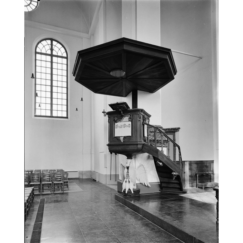 a small metal baptismal dish is mounted on the side of the stairs [cf. FontNotes] -- the base of the pulpit is a curious-looking pelican in its next