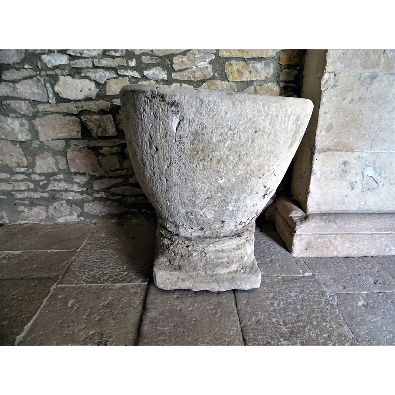 the baptismal font originally from Relloso shown here at the entrance of the church in Quincoces de Yuso