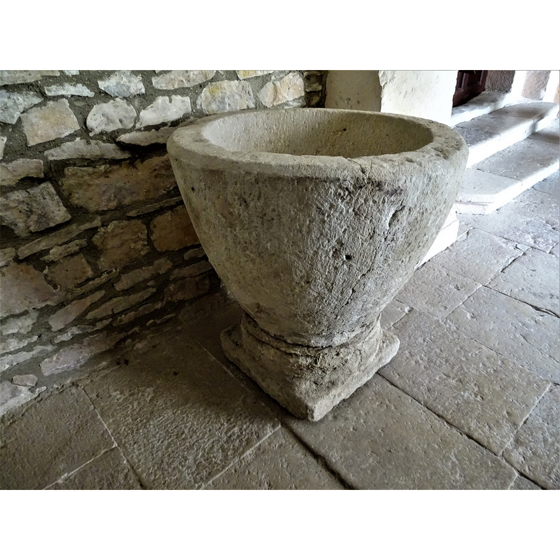 the baptismal font originally from Relloso shown here at the entrance of the church in Quincoces de Yuso