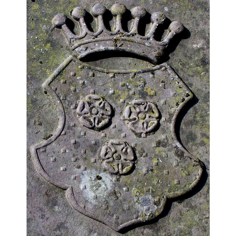 Source caption: "Wappen der Familie von Trümbach auf dem Grabstein von Friedrich Wilhelm Siegmund Freiherr von Trümbach auf Wehrda (*22. Februar 1833, † 9. Juli 1883), auf dem Friedhof in der Nähe der Ruine Altwehrda" -- showing the three-rose symbol that also appears on the side of the baptismal font in Wehrda