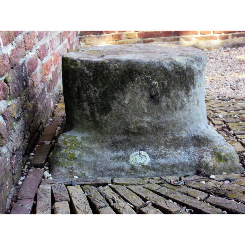 the base of the medieval font here, according to one source [cf. FontNotes]: Outside the church is the base and column of the font, and these were used as "roepsteen" or "pierre de criée" for public announcements.